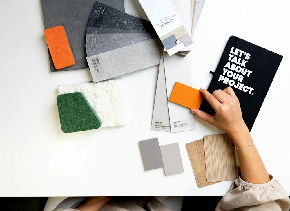 Fabric swatches, stone samples and a notebook spread across a white table.
